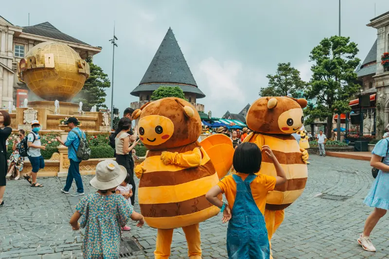 Kids standing in Front of Bee mascots