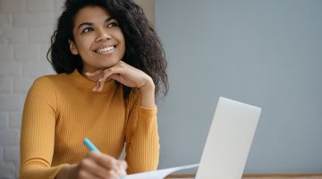 Young happy female student in front of her laptop