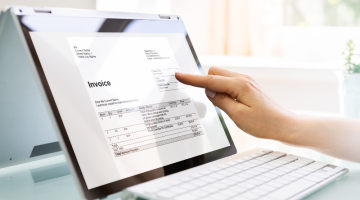 Person working on invoices on laptop computer