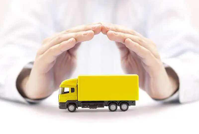 Hand of a person covering the yellow toy truck