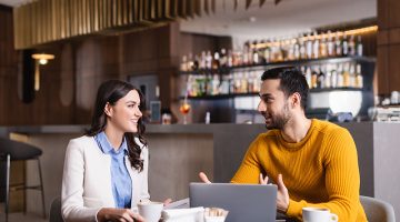 Young man and woman business owner talking inside the restaurant bar