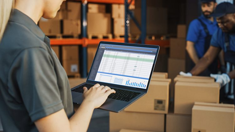 Manager using laptop computer for product inventory