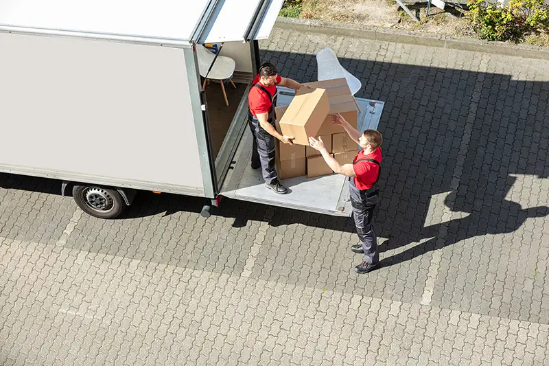 An Overhead View Of A Male Movers Unloading The Cardboard Boxes Form Truck 