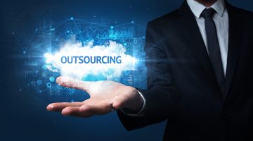 Hand of Businessman holding OUTSOURCING inscription