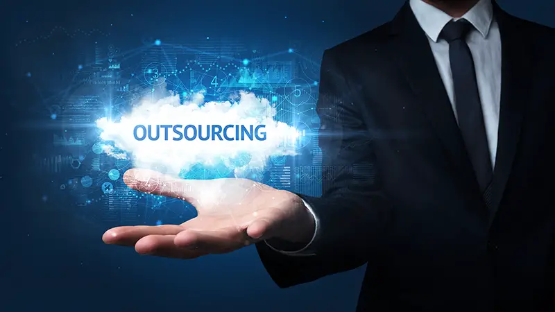 Hand of Businessman holding OUTSOURCING inscription