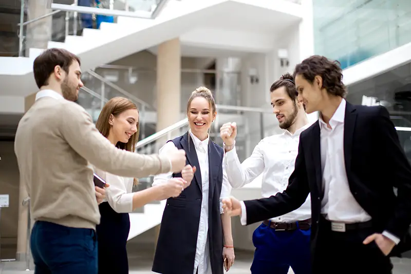 happy business team playing rock paper scissors at modern office