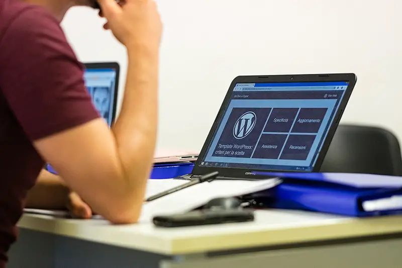 Person sitting in front of laptop with WordPress site on the screen