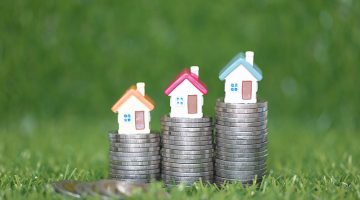 Finance, Model house on Stack of coins money on natural green background