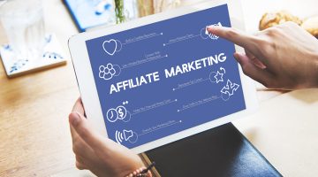 Woman holding digital tablet in hands with affiliate marketing on screen