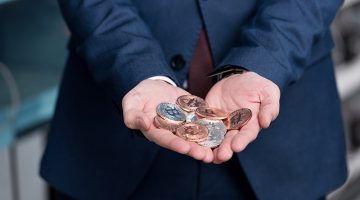 businessman with heap of bitcoin on his hands