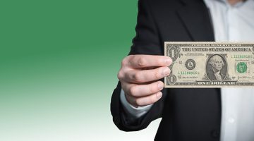 Businessman holding a dollar note