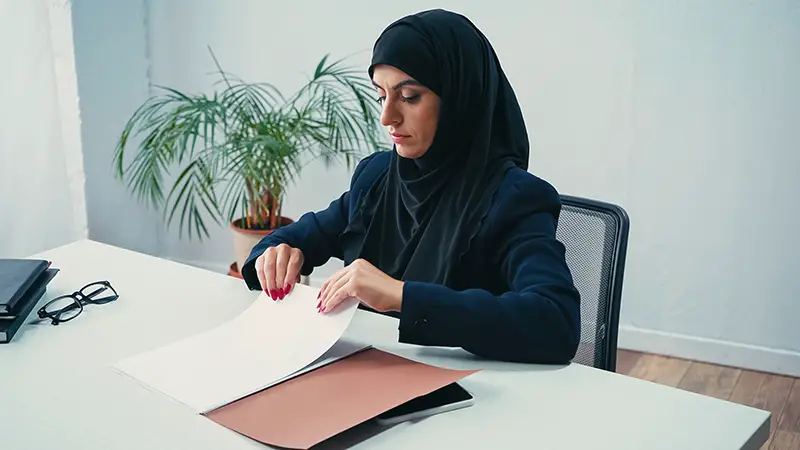 Muslim businesswoman in hijab working with documents