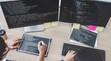 Two professional programmers cooperating at Developing programming and website working in a software develop company office