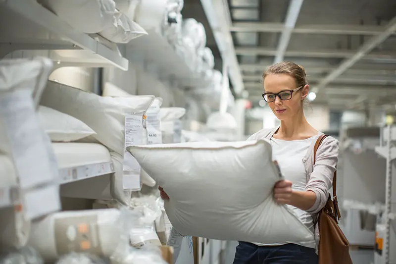 young woman choosing the right pillow for her bed