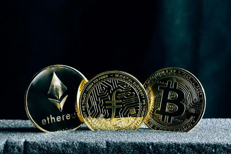 three bitcoins sitting on-top of a table