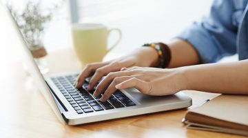 Female hands typing on laptop
