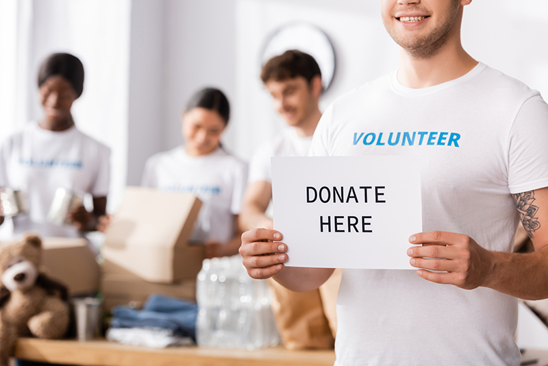 volunteer holding card with donate word