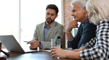 Male notary working with mature couple in office