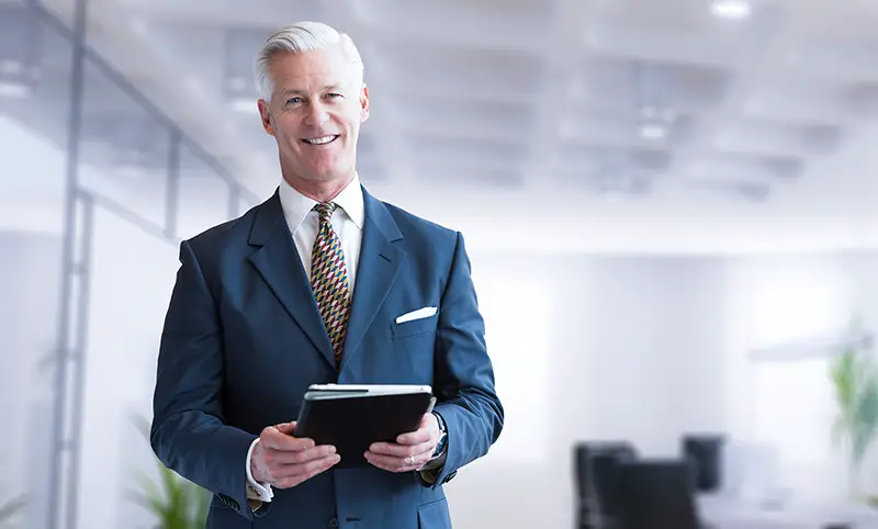 Portrait of senior businessman using tablet in front of his modern office