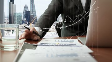 business documents on office table with smart phone and digital tablet and graph business diagram