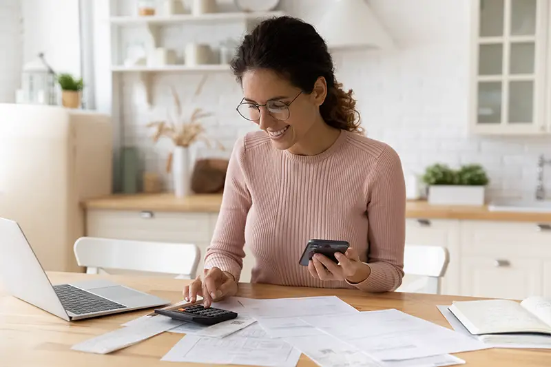 Smiling woman making a tax calculation