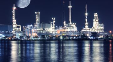 Big moon over oil refinery plant night scene nearby river in Thailand