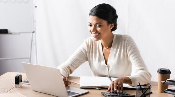 Happy african american woman looking at laptop