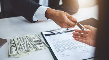 Businessman giving pen to businesswoman for signing contract banking money loaning