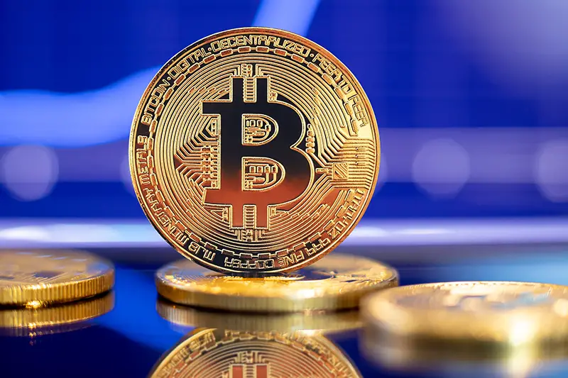 Gold Bitcoin crypto currency on background of chart diagram.