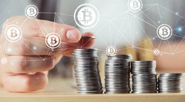 Person stacking bitcoins