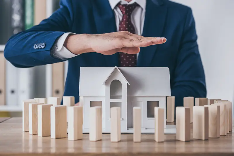 Cropped view of risk manager covering house model