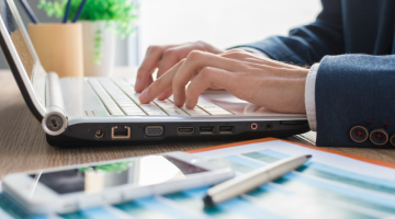 Hands typing on laptop keyboard
