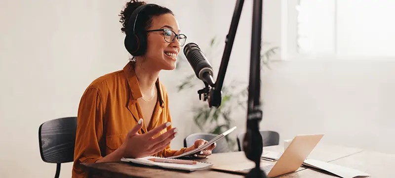 Female podcaster making audio podcast from her home studio.