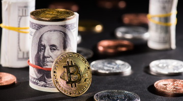 Close-up view of rolled dollar banknotes and bitcoin