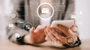 Cropped view of businesswoman using smartphone in office with email icons