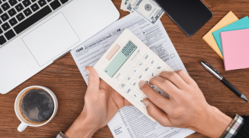 Cropped view of man using calculator with tax form