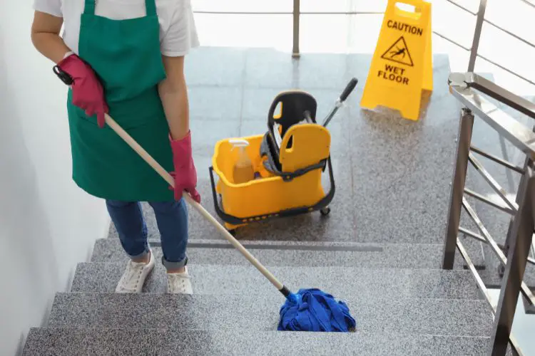 Cleaner using a mop to clean the stairs