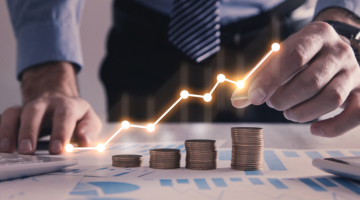 Man stacking coins with a graph of profit