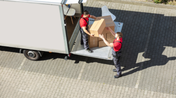 An Overhead View Of A Male Movers Unloading the cardboard boxes form from truck