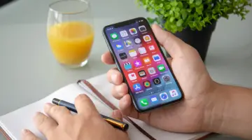 Man hand holding iPhone X with home screen IOS