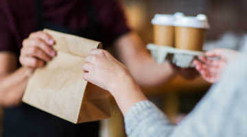 Man or bartender serving customer at coffee shop for takeaway orders