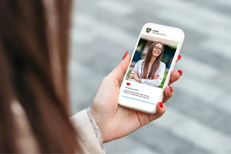 Woman looking at beautiful model's photo on mobile phone
