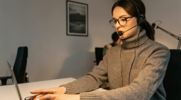 Woman in Gray Sweater Using a Laptop