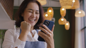 Asia mature adult woman people wear apron small cafe receive e-mail text good news SME lending service solution win seller store in social media app