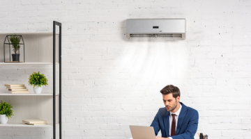 businessman using laptop while sitting at work under the air condition