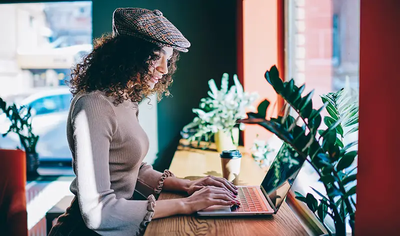 trendy hipster girl blogging in social networks using 4g wireless internet on computer