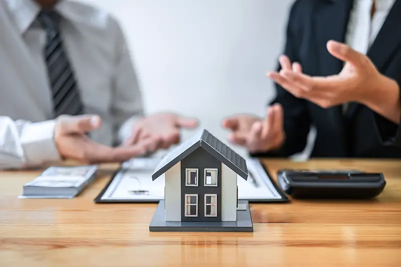 Estate agent are presenting home loan and giving house to client after discussing and signing