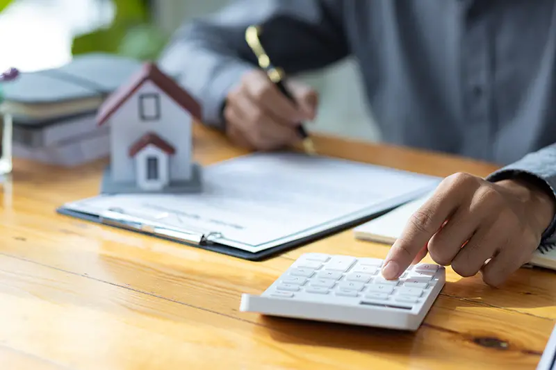 Business people calculating interest, taxes and profits to invest in real estate and home buying.