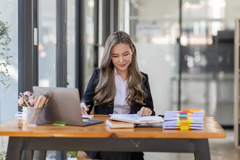 business Asian woman or accountant Bookkeeper working on calculator to calculate business data