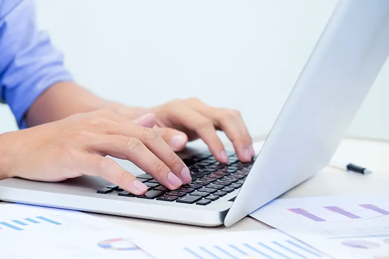 Man's hands typing on laptop keyboard